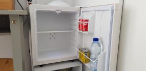 an open refrigerator with drinks and soda in it at Chambre d'hôtes Entre-deux Lacs in Biscarrosse