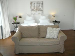 a couch in a living room with a bed at Villa Silbermöwe in Wyk auf Föhr