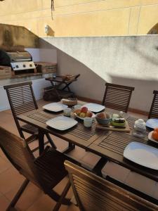 a table with plates and bowls of fruit on it at Chalet en playa de Almardá in Almarda