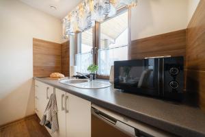 a kitchen with a microwave and a sink at Leśne Tarasy in Jastrzębia Góra