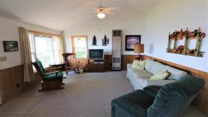 a living room with a couch and a tv at Sunset Shore in Petoskey