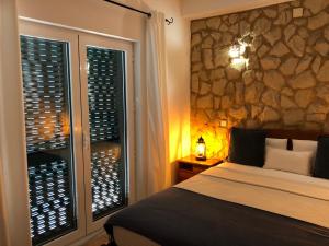 1 dormitorio con cama y pared de piedra en Casa GiGi, en Sagres