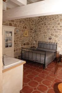 Les AssionsにあるGîtes Mas de la Musardièreの石の壁の中にベッドが置かれた寝室 +81枚の写真