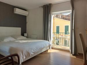 sypialnia z łóżkiem i widokiem na balkon w obiekcie In the hart of old Cannes - Place du Suquet - 2 Min Walking distance from Palais de Festivals and Beaches w Cannes
