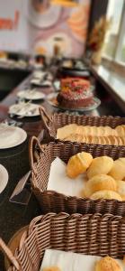 una mesa con cestas de pan y platos de comida en HOTEL BRASIL en Boa Esperança