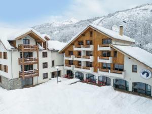 a hotel in the snow with snow covered buildings at Cristal Lodge by Daddy Pool- TERRESENS in Saint-Chaffrey