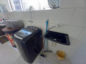 TV y lavabo en una habitación en Pé na areia, en Recife