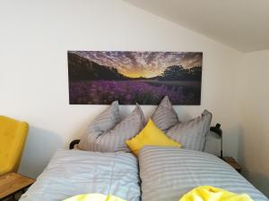 ein Bett mit Kissen und ein Gemälde an der Wand in der Unterkunft Quartier No. 7 - Serviced Living in Grödig