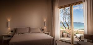 a bedroom with a bed and a large window at Cala Cuncheddi - VRetreats in Murta Maria