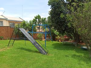 un parque infantil con un tobogán en un patio en Chez Jeanne Auberge en Talata-maty