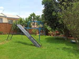 a playground with a slide in a yard at Chez Jeanne Auberge Antananarivo in Talata-maty