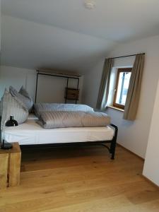 a bed sitting in a room with a window at Quartier No. 7 - Serviced Living in Grödig