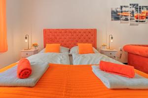 1 Schlafzimmer mit 2 Betten und orangefarbenen Kissen in der Unterkunft Rezidence Znojmo in Znojmo