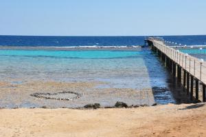 une jetée sur la plage avec un cœur dans l'eau dans l'établissement Wadi Lahmy Azur Resort - Soft All-Inclusive, à Abū Ghuşūn