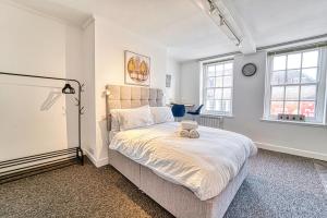 a bedroom with a large bed and two windows at Guest Homes - Hills Apartments in Worcester