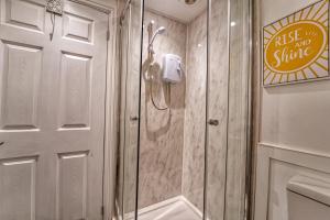 a shower with a glass door in a bathroom at Guest Homes - Hills Apartments in Worcester