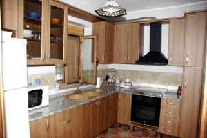 a kitchen with wooden cabinets and a sink at Rural Fábrica del Azúcar 1 in Pozo Alcón