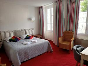 une chambre d'hôtel avec un lit et une chaise dans l'établissement Hotel Saint Amant, au Palais