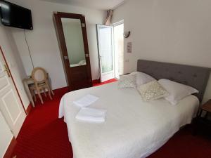 a bedroom with a white bed with two napkins on it at Hotel Saint Amant in Le Palais