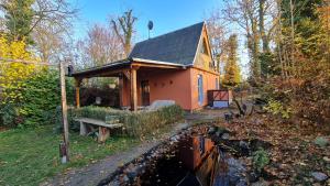 a small house in the woods next to a body of water at Behagliches Haus mit Kamin und Wärmepumpe 