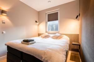 um quarto com uma cama grande e uma janela em Luxe appartement in haven Marina Kamperland - 2 badkamers em Kamperland