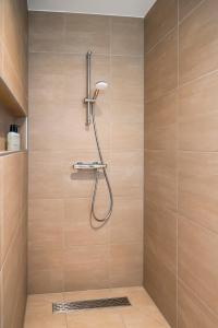 y baño con ducha con cabezal de ducha. en Luxe appartement in haven Marina Kamperland - 2 badkamers, en Kamperland