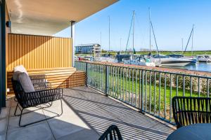 een balkon met stoelen en uitzicht op een jachthaven bij Luxe appartement in haven Marina Kamperland - 2 badkamers in Kamperland