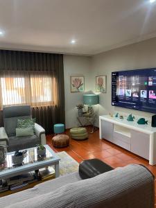 sala de estar con TV de pantalla plana grande en Barrosa House, en Vila Praia de Âncora