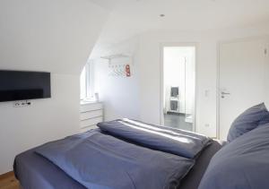 a bedroom with a bed and a flat screen tv at Residenz Kirchberg in Adenau