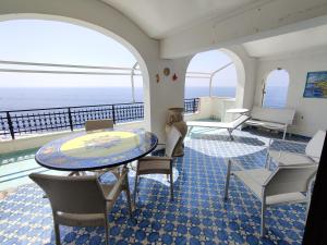 a room with a table and chairs and the ocean at Casa La Scogliera in Praiano