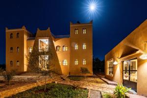 een gebouw 's nachts met de maan in de lucht bij Le Domaine M in Ouzoud