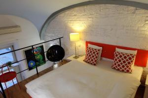 a bedroom with a large white bed and a brick wall at Art & Design Studios in Budapest