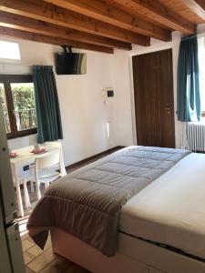 a bedroom with a bed and a desk and a window at Bergamo Easy Airport private parking in Bergamo