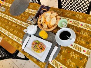 a table with a plate of food and a cup of coffee at GRACE LODGE in Lomé