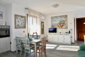 - un salon avec une table, des chaises et une télévision dans l'établissement SOL LEONE, à Porto Torres