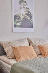 ein Bett mit Kissen und ein Bild an der Wand in der Unterkunft Bärbel, im Schwarzwald-Stil in Baiersbronn