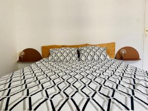 ein schwarz-weißes Bett in einem Schlafzimmer in der Unterkunft Appartement 4 pers max à Seignosse le Penon in Seignosse