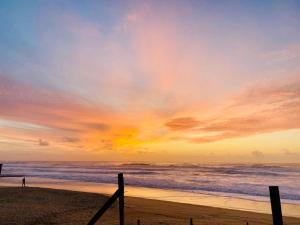 eine Person, die bei Sonnenuntergang am Strand spazieren geht in der Unterkunft Appartement 4 pers max à Seignosse le Penon in Seignosse