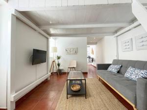 a living room with a couch and a tv at Villas Pedroso - Villa Palmira in Cascais