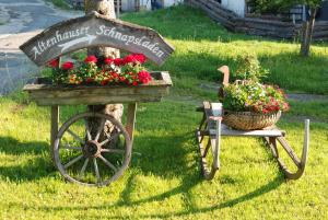 a flower cart with a sign and a basket of flowers at Altenhausner Hof in Kössen