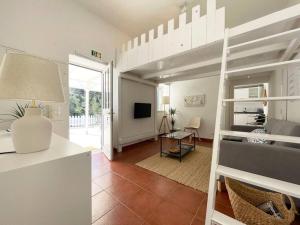 a room with a bunk bed and a living room at Villas Pedroso - Villa Palmira in Cascais