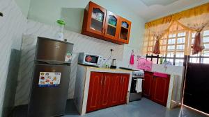 a kitchen with a refrigerator and red cabinets at Pinnacle Homes in Naivasha