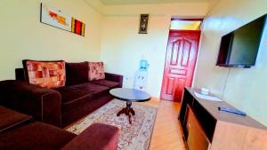 a living room with a couch and a red door at Pinnacle Homes in Naivasha