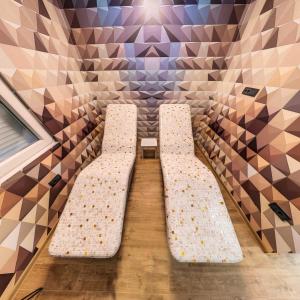 una camera con due panche bianche in una stanza con piastrelle di Relax House NS a Novi Sad