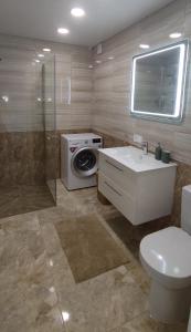 a bathroom with a toilet sink and a washing machine at NEW Apartment J22, Free Private Parking, Terrace, Self Check-in in Kaunas