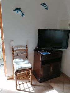 ロジルにあるCasa da Samouqueiraの椅子とテレビが備わる客室です。