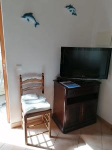 a chair and a television in a room at Casa da Samouqueira in Rogil