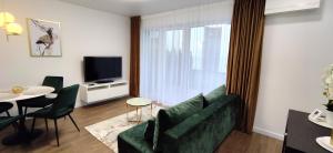a living room with a green couch and a table at NEW Apartment J22, Free Private Parking, Terrace, Self Check-in in Kaunas
