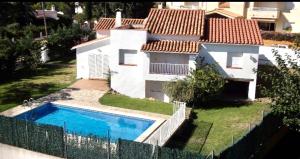 une maison avec une piscine dans une cour dans l'établissement La Casita, à L'Escala