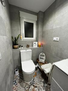 een badkamer met een toilet en een tv aan de muur bij ALCOY-DENIA in Denia